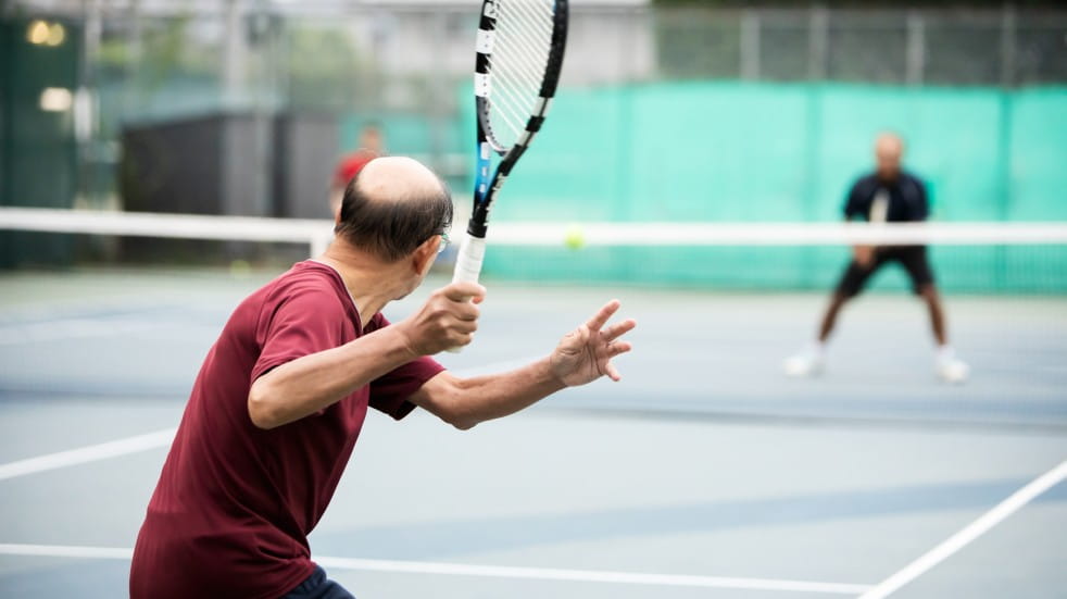 older man playing tennis